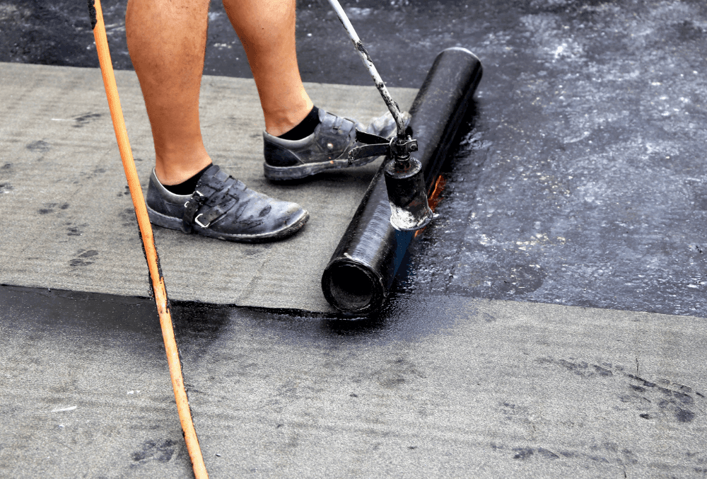 Contractor applying waterproof coating to garage floor for protection and durability.