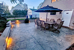 stamped concrete patio with garden chairs and table