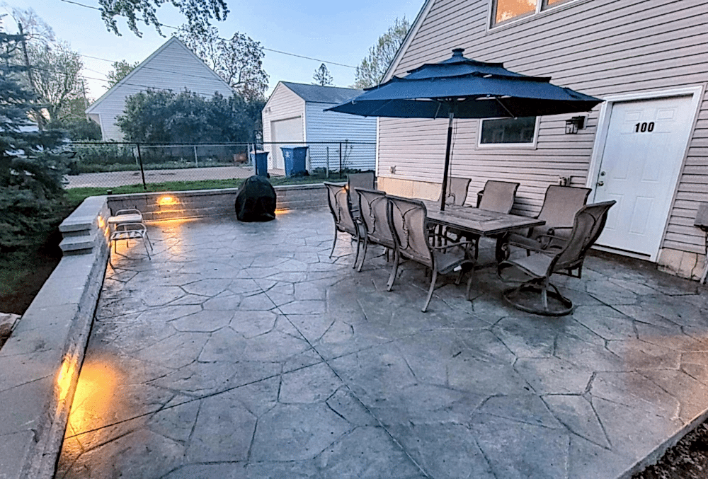 stamped concrete patio with garden chairs and table