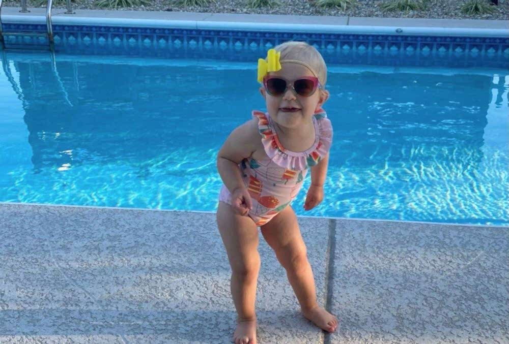 concrete pool deck with a pretty kid smiling