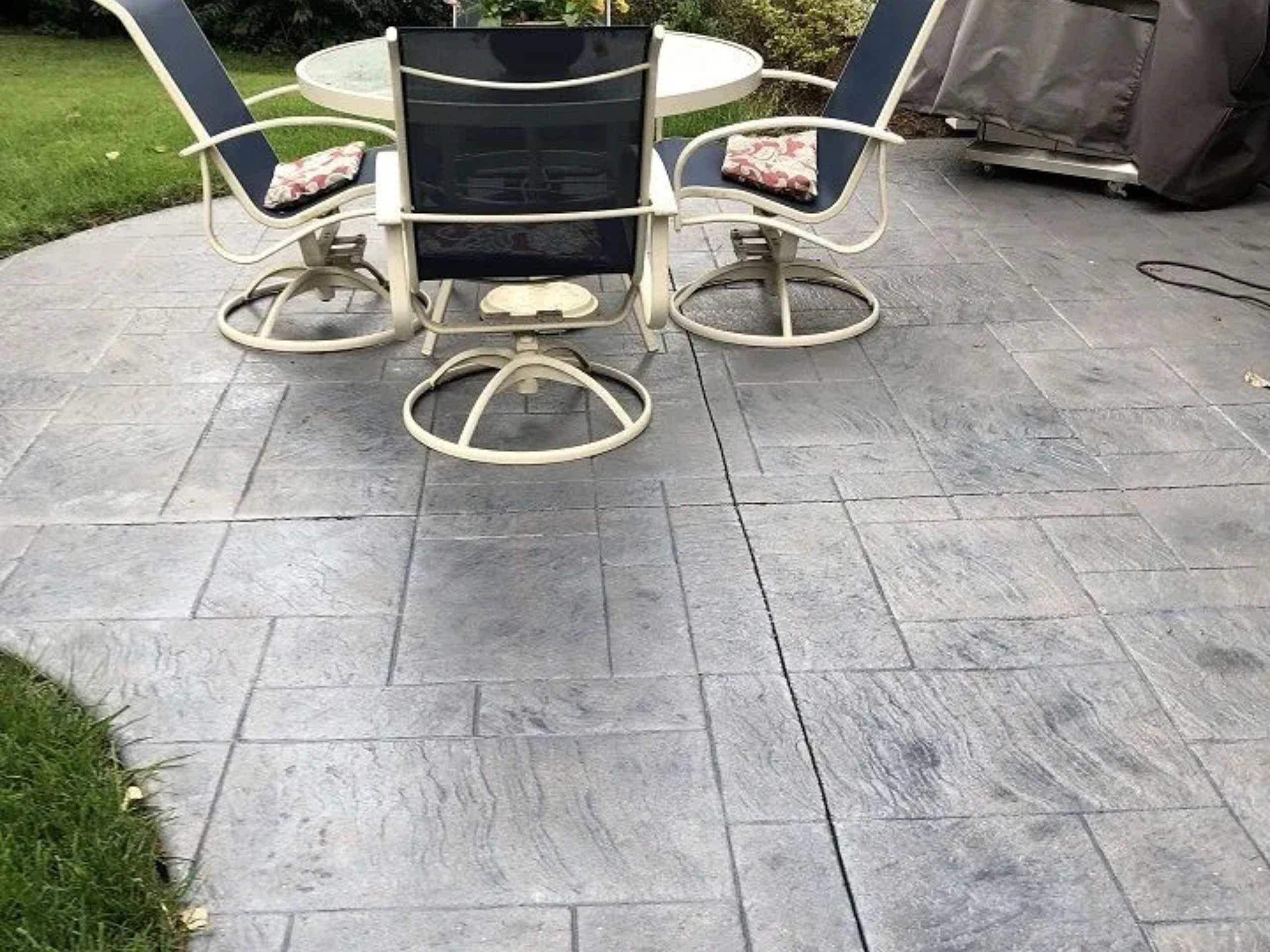 Patio resurfacing creating a refreshed outdoor seating area with a table and chairs.